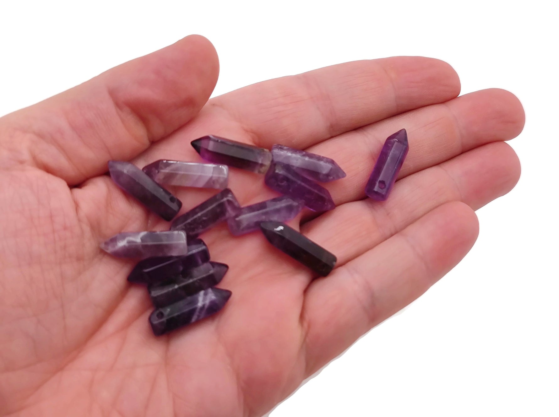 Amethyst point crystal pendant with drilled hole, showcasing purple gemstone and natural crystal formations.