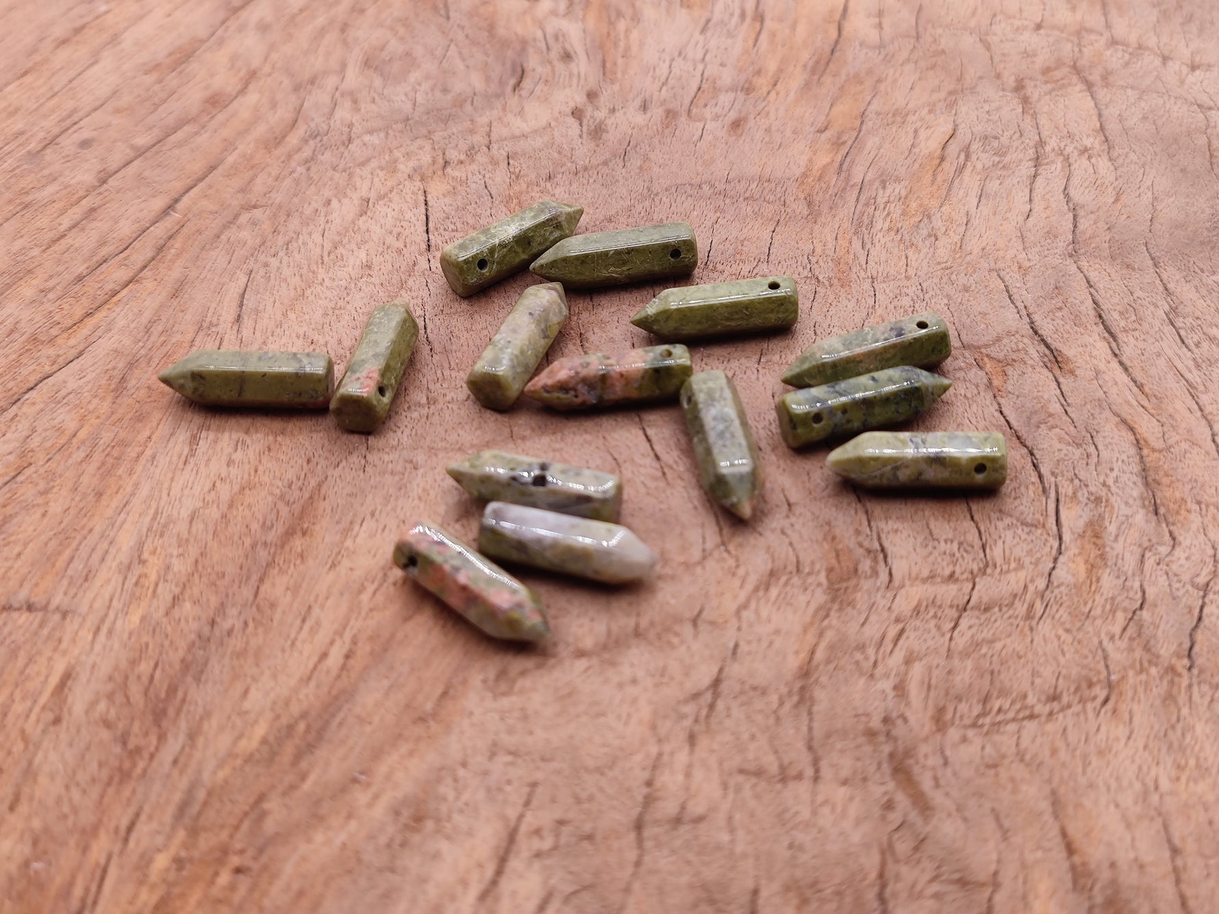 Unakite point hole crystal pendant from GemstoneGO, featuring a drilled natural gemstone with a smooth, polished surface.