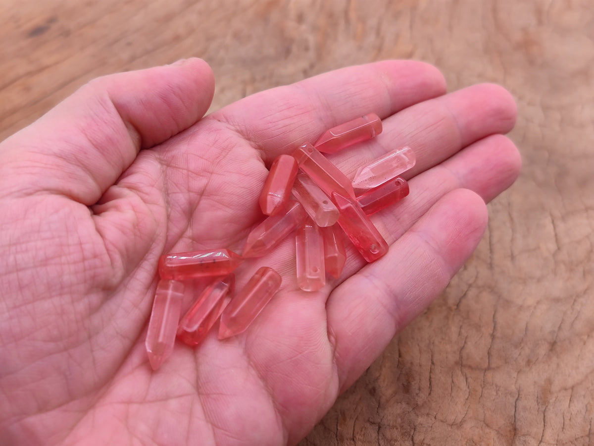 Cherry quartz point crystal pendant with drilled hole, showcasing a vibrant red gemstone from GemstoneGO.