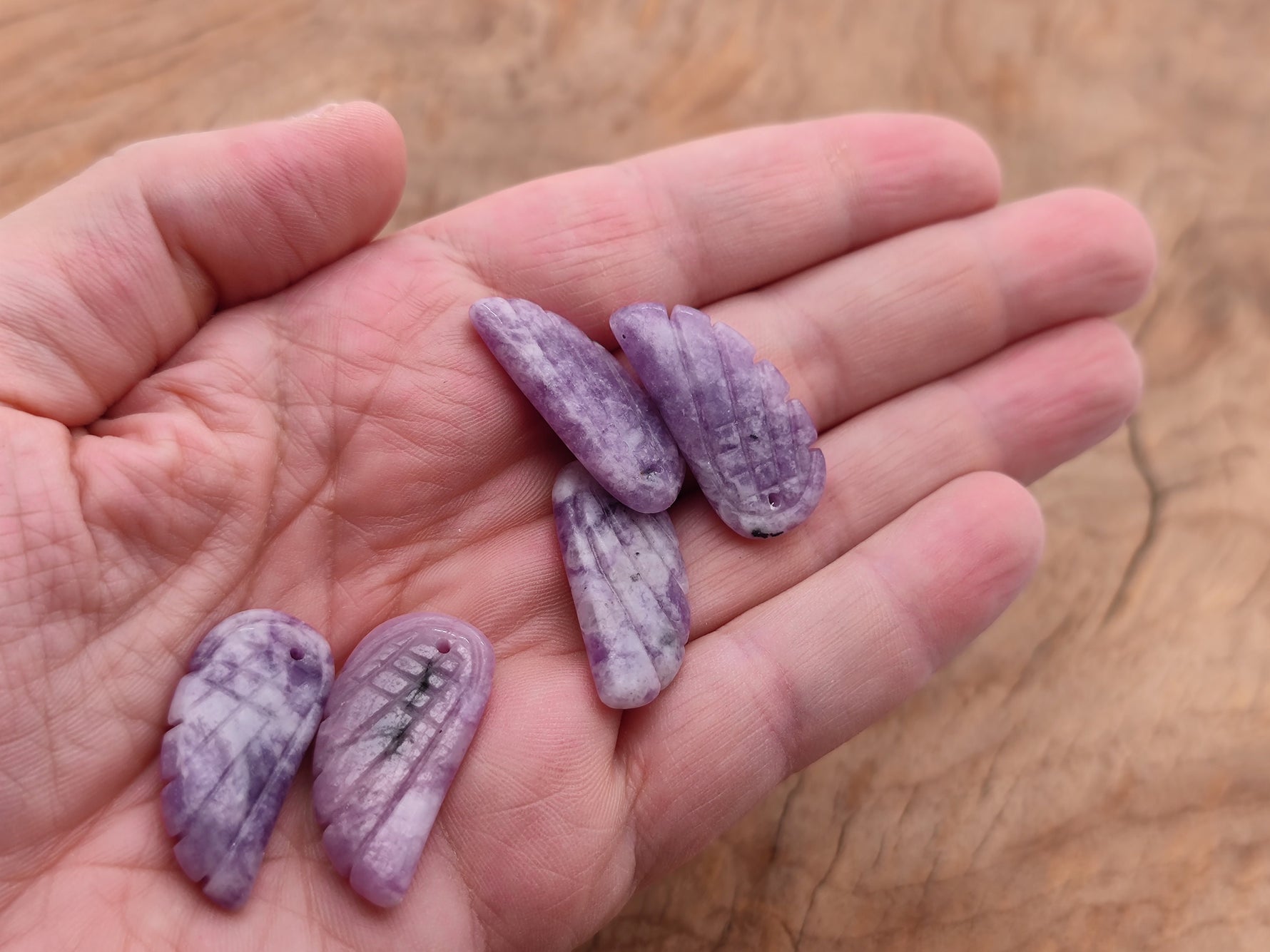 Lepidolite angel wing crystal pendant with hole charm from GemstoneGO, showing detailed purple and pink mineral textures