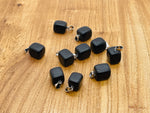 Obsidian tumbled gemstone pendant with natural black stone and smooth polished surface, pendant displayed on a white background.