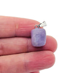 Lepidolite tumbled gemstone pendant with purple and gray hues, displayed on a neutral background, showcasing its smooth, polished surface.