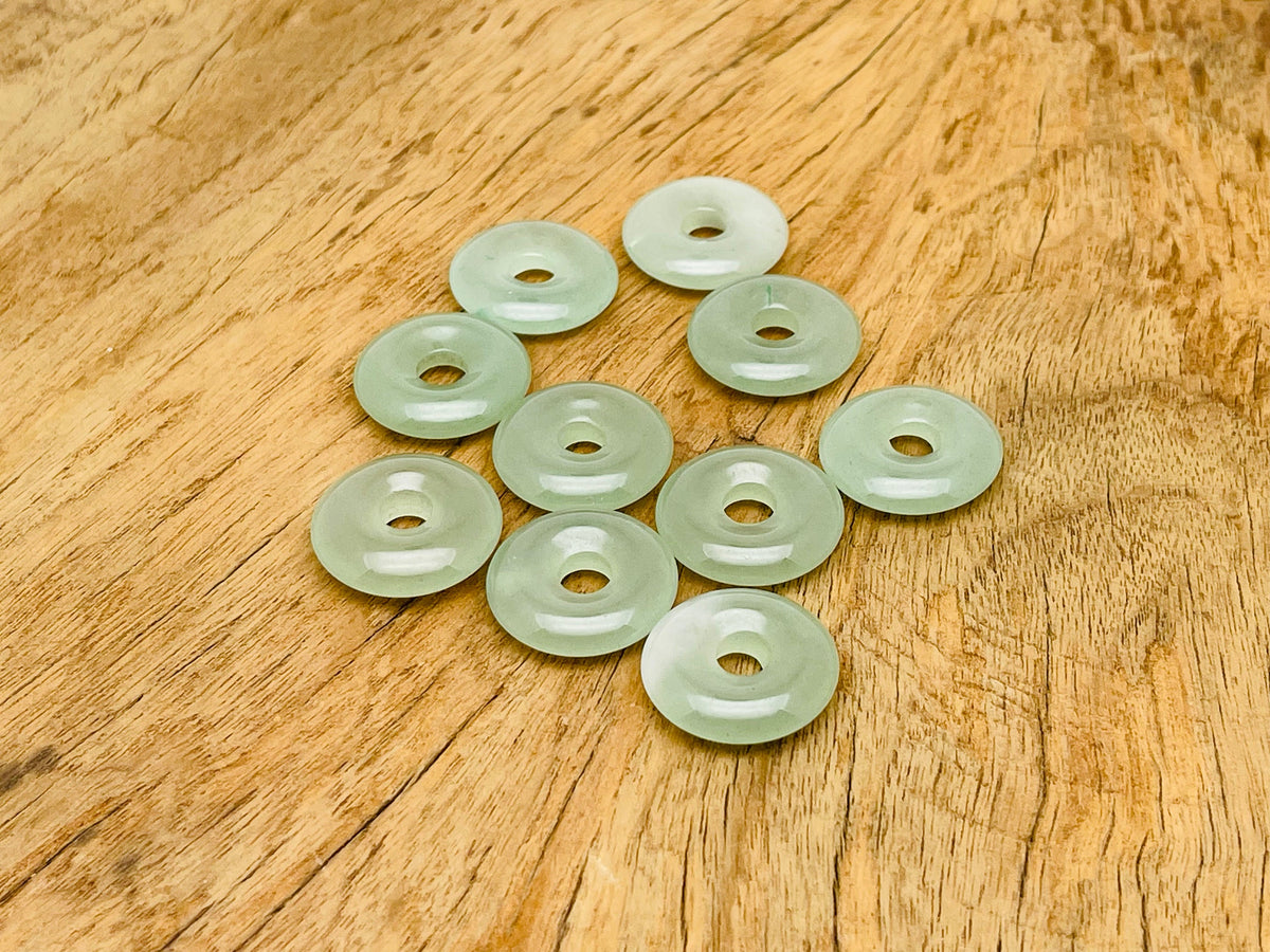 A 20mm aventurine crystal donut pendant with natural green gemstone, showcasing its polished, smooth, circular shape and vibrant color.