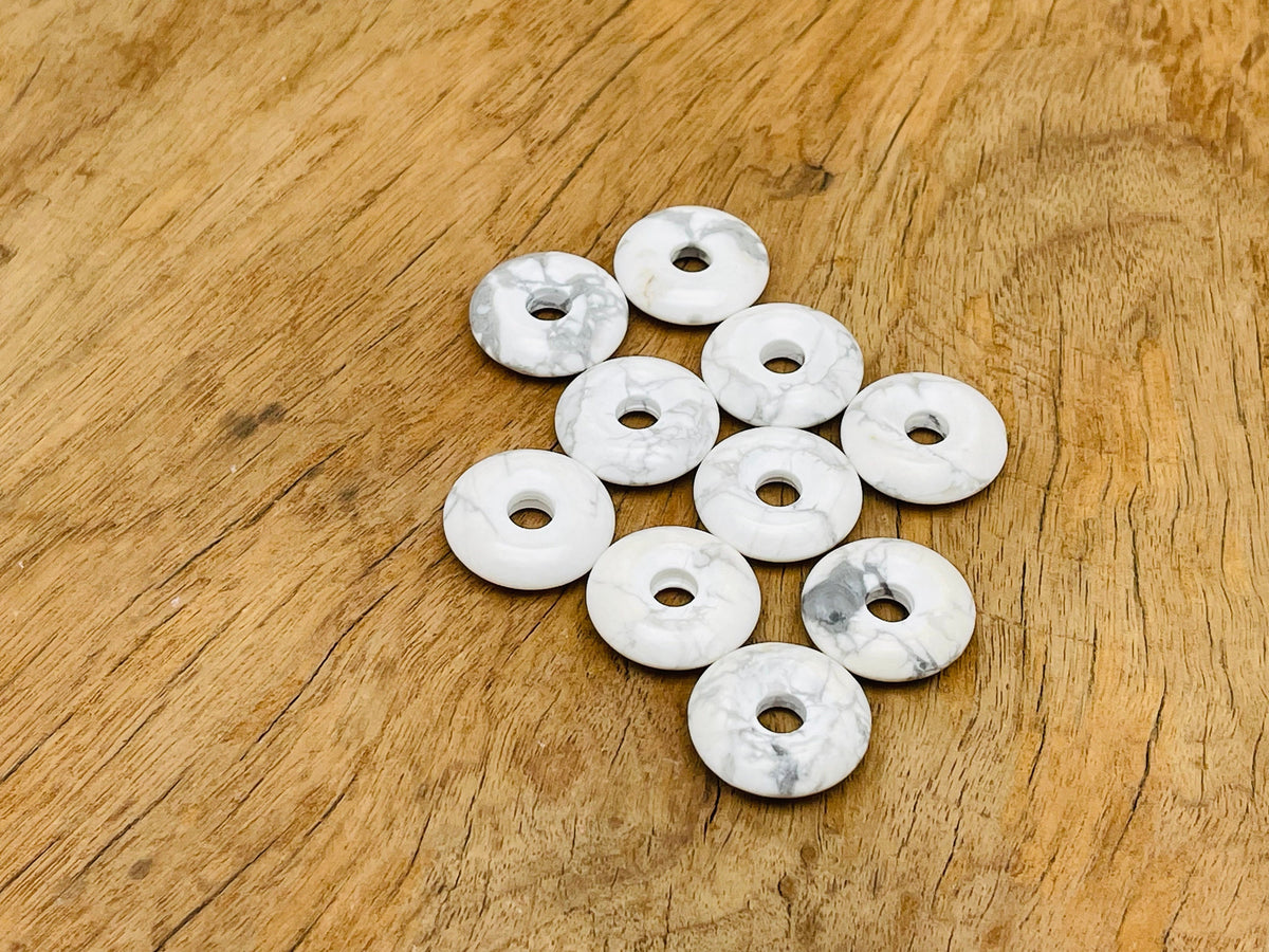 Howlite crystal donut pendant, 20mm Pi stone, from GemstoneGO, featuring white and gray marbled patterns on a smooth round shape.
