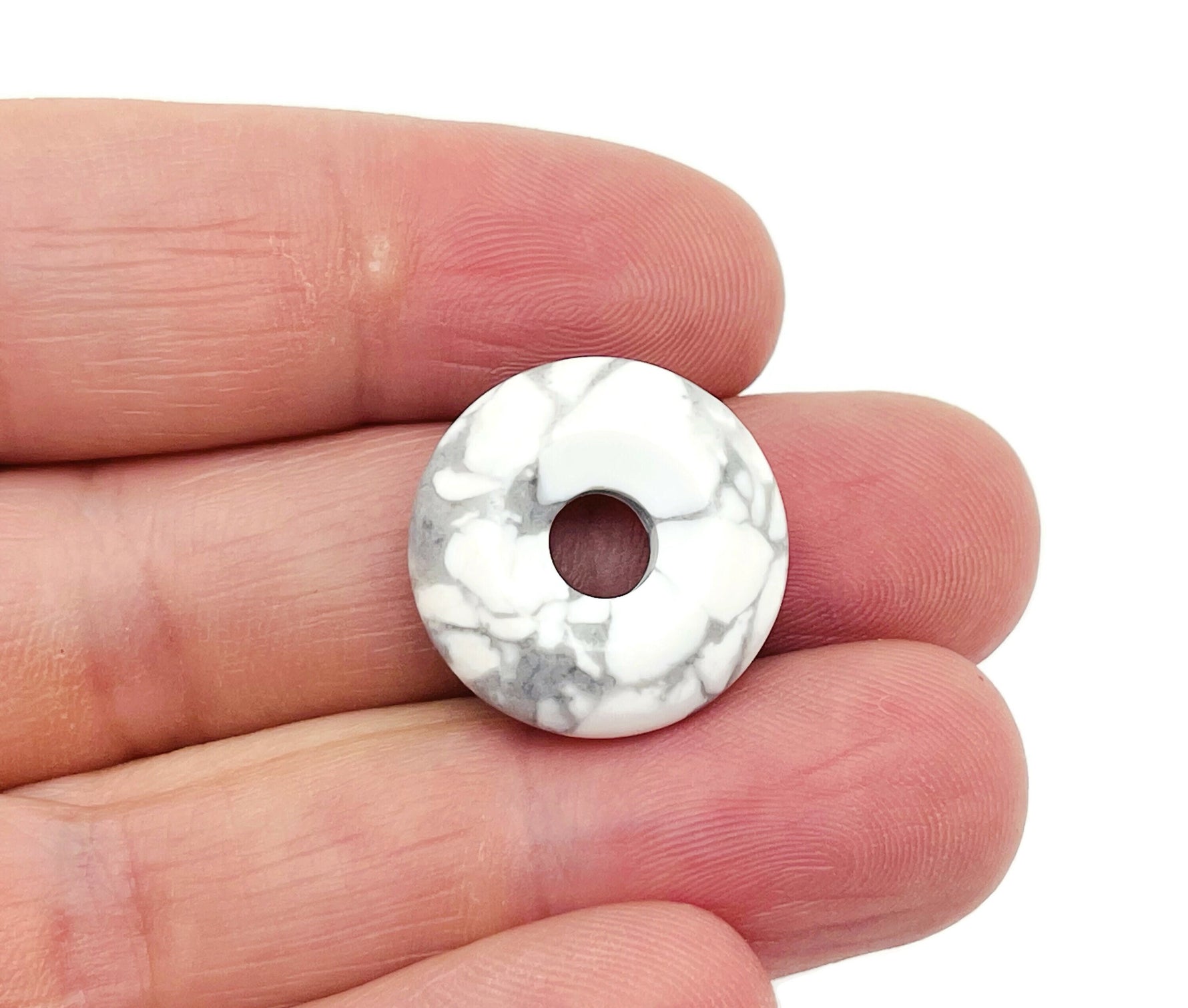 Howlite crystal donut pendant, 20mm Pi stone from GemstoneGO, showcasing a smooth white and gray marbled gemstone.