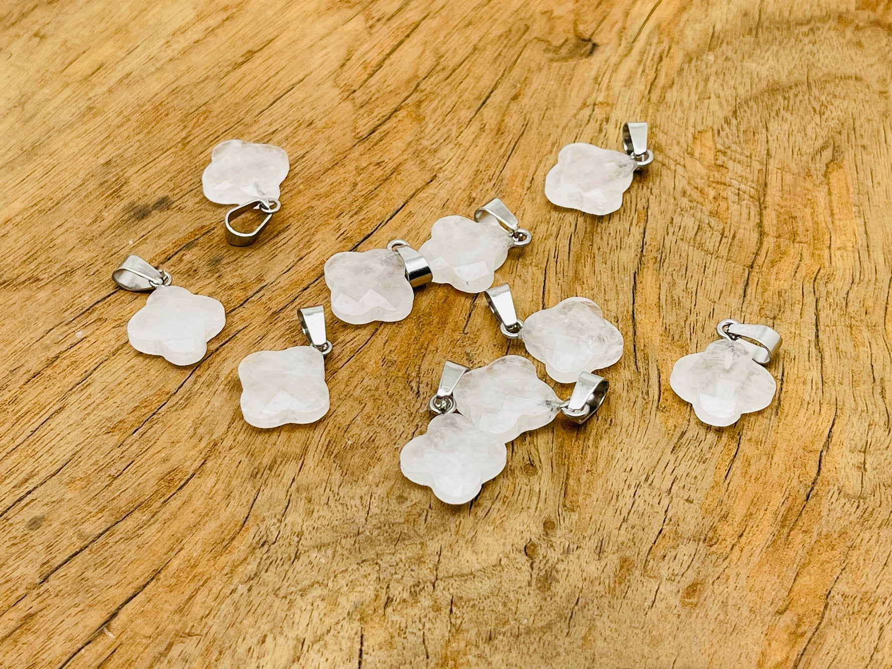 Clear quartz four-leaf clover crystal pendant from GemstoneGO, showcasing a sparkling DIY jewelry-making supply with a silver bail.