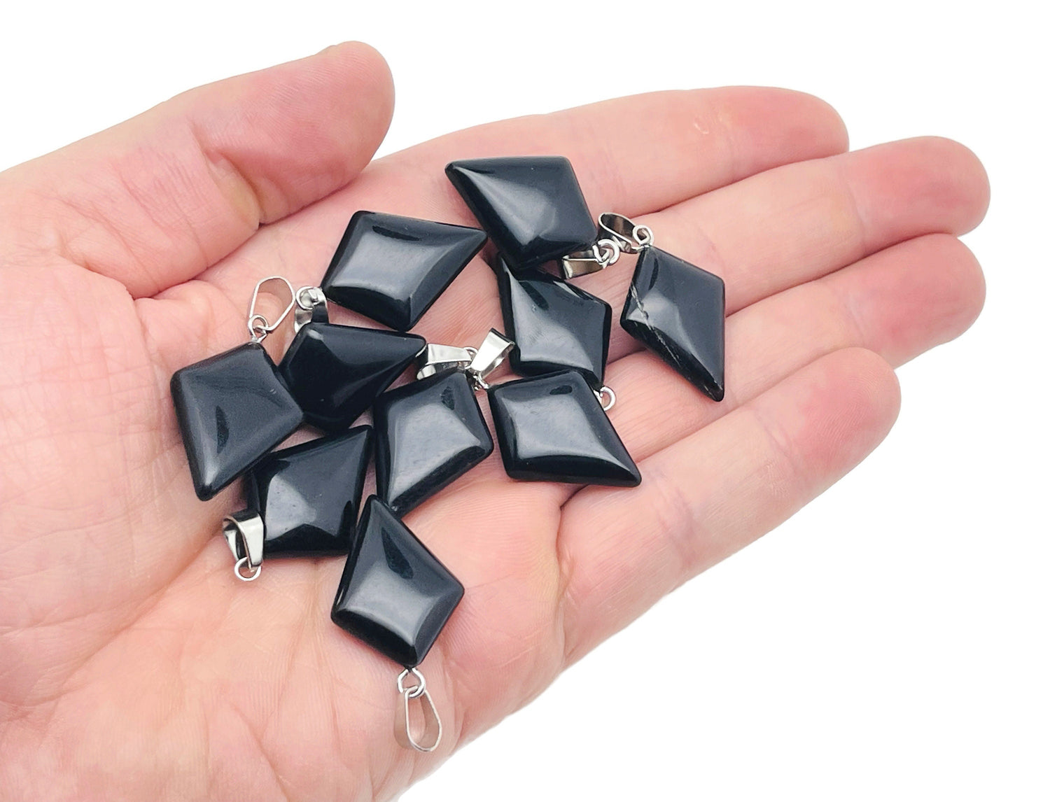 Obsidian triangle gemstone pendant with geometric design, showcasing a polished black gemstone on a silver chain.