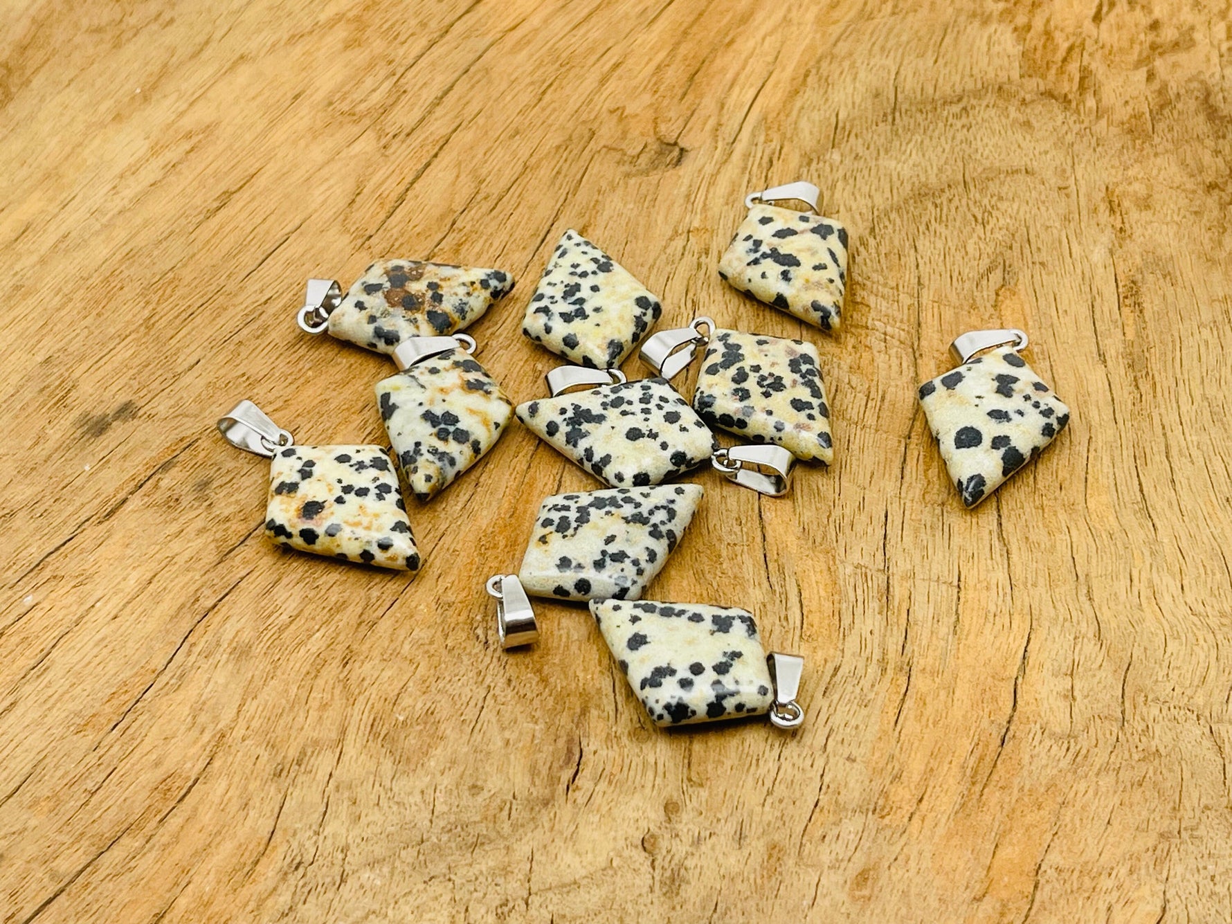 Dalmatian Jasper triangle gemstone pendant from GemstoneGO featuring natural black and white spotted stone with a geometric design.