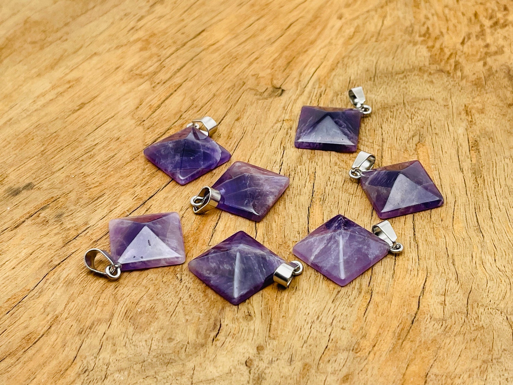 Amethyst pyramid gemstone pendant from GemstoneGO showcasing a natural purple amethyst crystal on a silver chain.