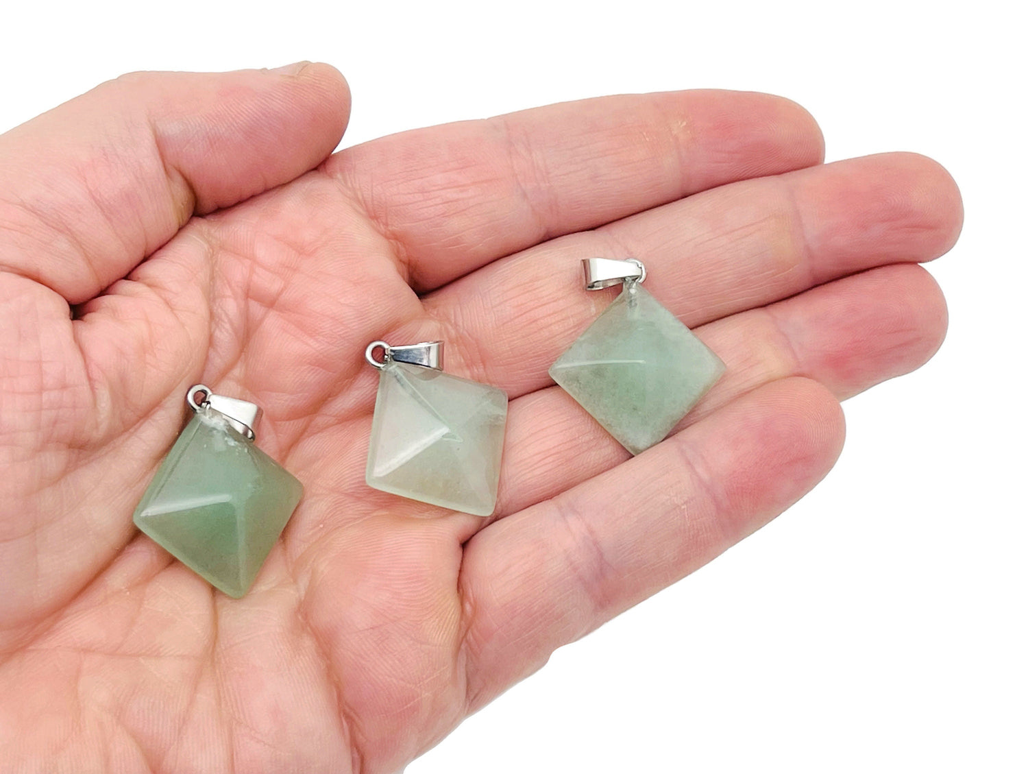 Aventurine pyramid gemstone pendant hanging from a cord, showcasing natural green gemstone with smooth facets.