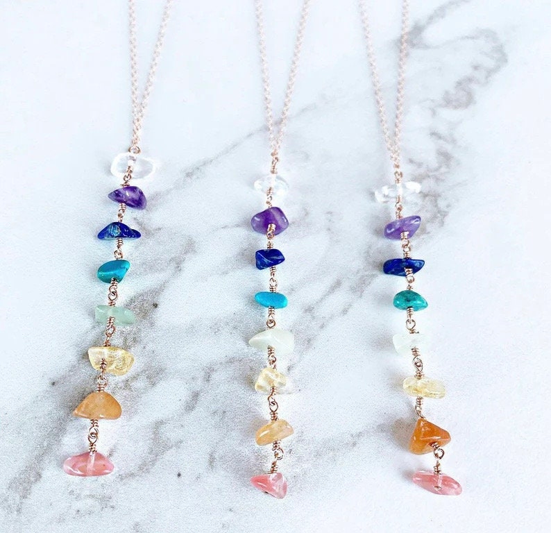 7 Chakra Crystal Necklace by GemstoneGO featuring silver and gold accents with colorful chakra gemstones on a chain