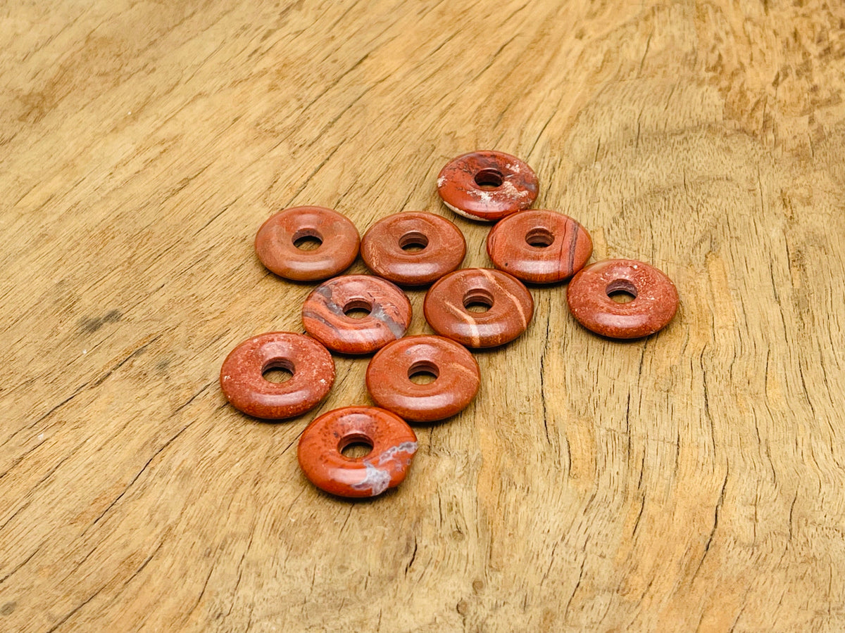 Red Jasper crystal donut pendant from GemstoneGO with a 20mm Pi Stone, showcasing a polished red jasper stone with natural patterns.