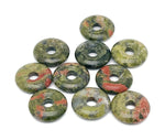 Unakite crystal donut pendant, 20mm Pi stone from GemstoneGO, showcasing the pink and green mottled gemstone with a hole in the center.