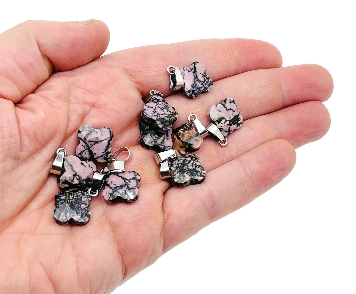 Rhodonite four-leaf clover crystal pendant from GemstoneGO, showcasing a pink and black gemstone charm for jewelry making.