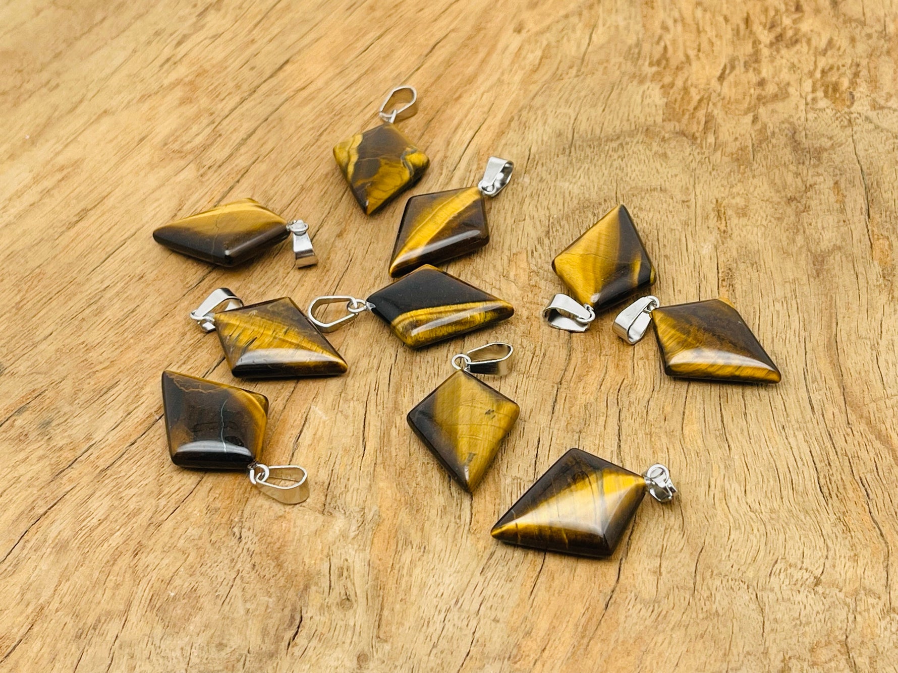 Tiger Eye triangle gemstone pendant featuring a geometric design, showcasing warm brown and golden hues, by GemstoneGO.
