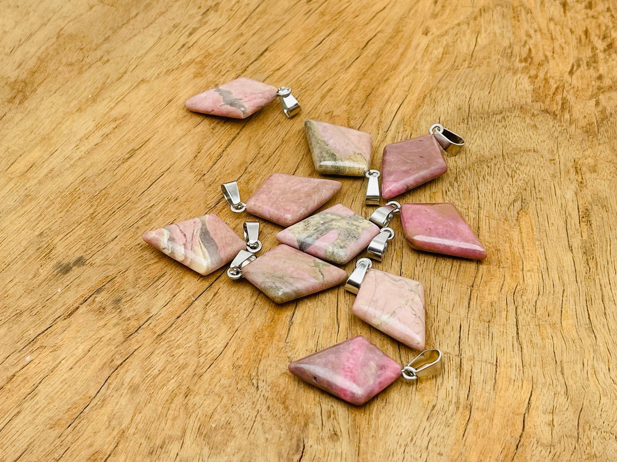 Rhodonite triangle gemstone pendant by GemstoneGO featuring a geometric design and polished finish, displayed against a neutral background.
