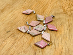Rhodonite triangle gemstone pendant by GemstoneGO featuring a geometric design and polished finish, displayed against a neutral background.