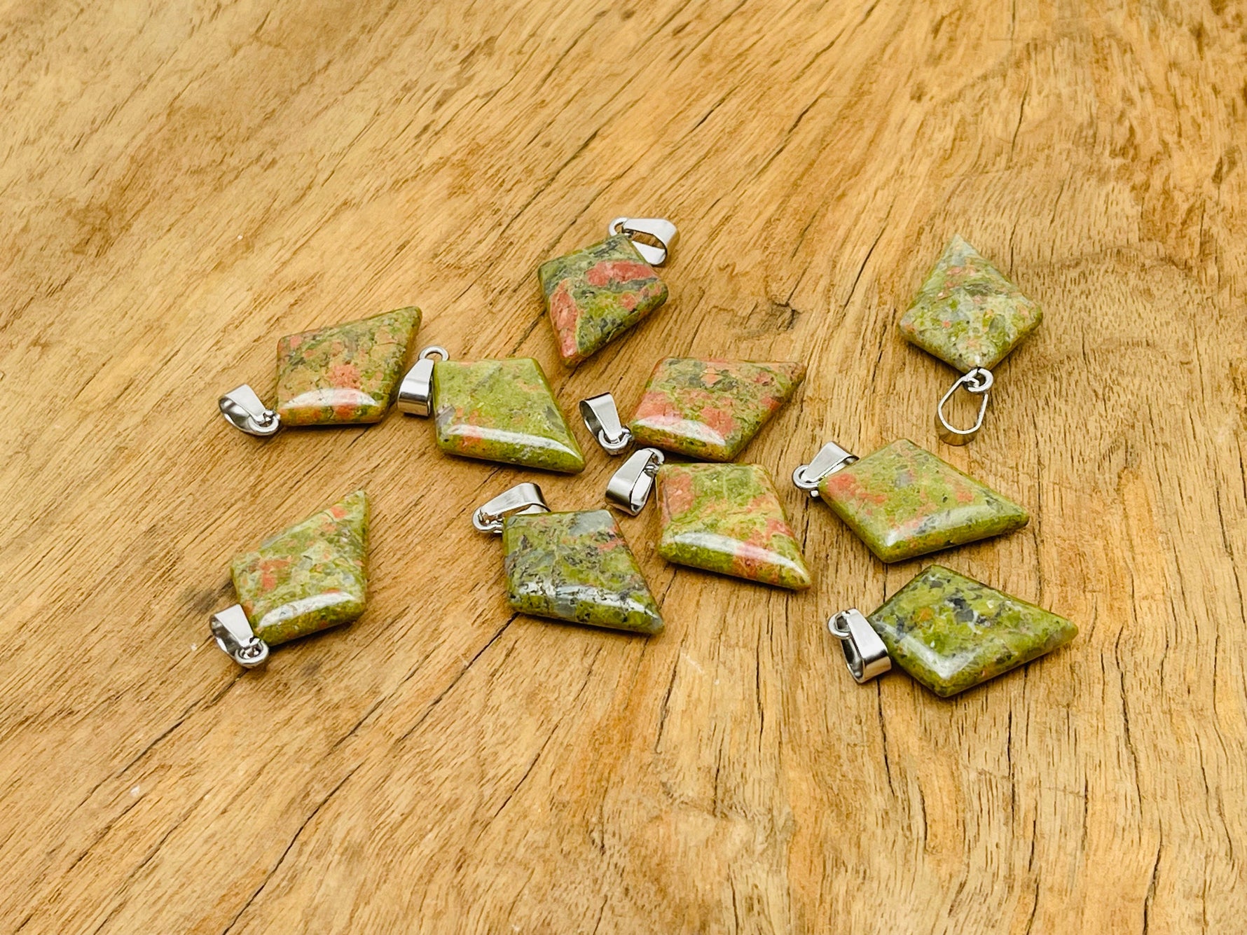 Unakite triangle gemstone pendant with geometric design, featuring vibrant green and pink hues, by GemstoneGO.