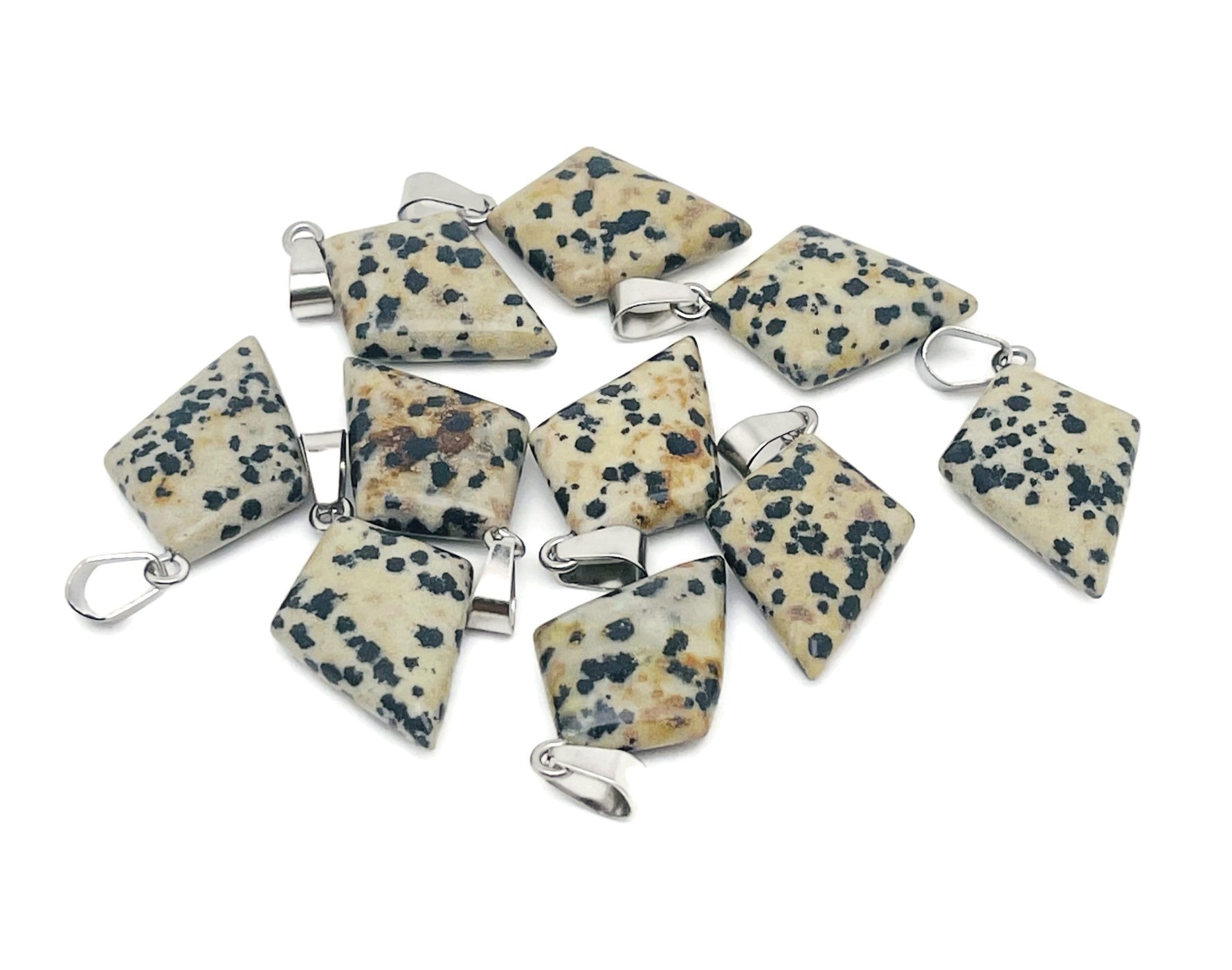 Dalmatian Jasper triangle gemstone pendant featuring a geometric design, showcasing black spots on a cream-colored stone.