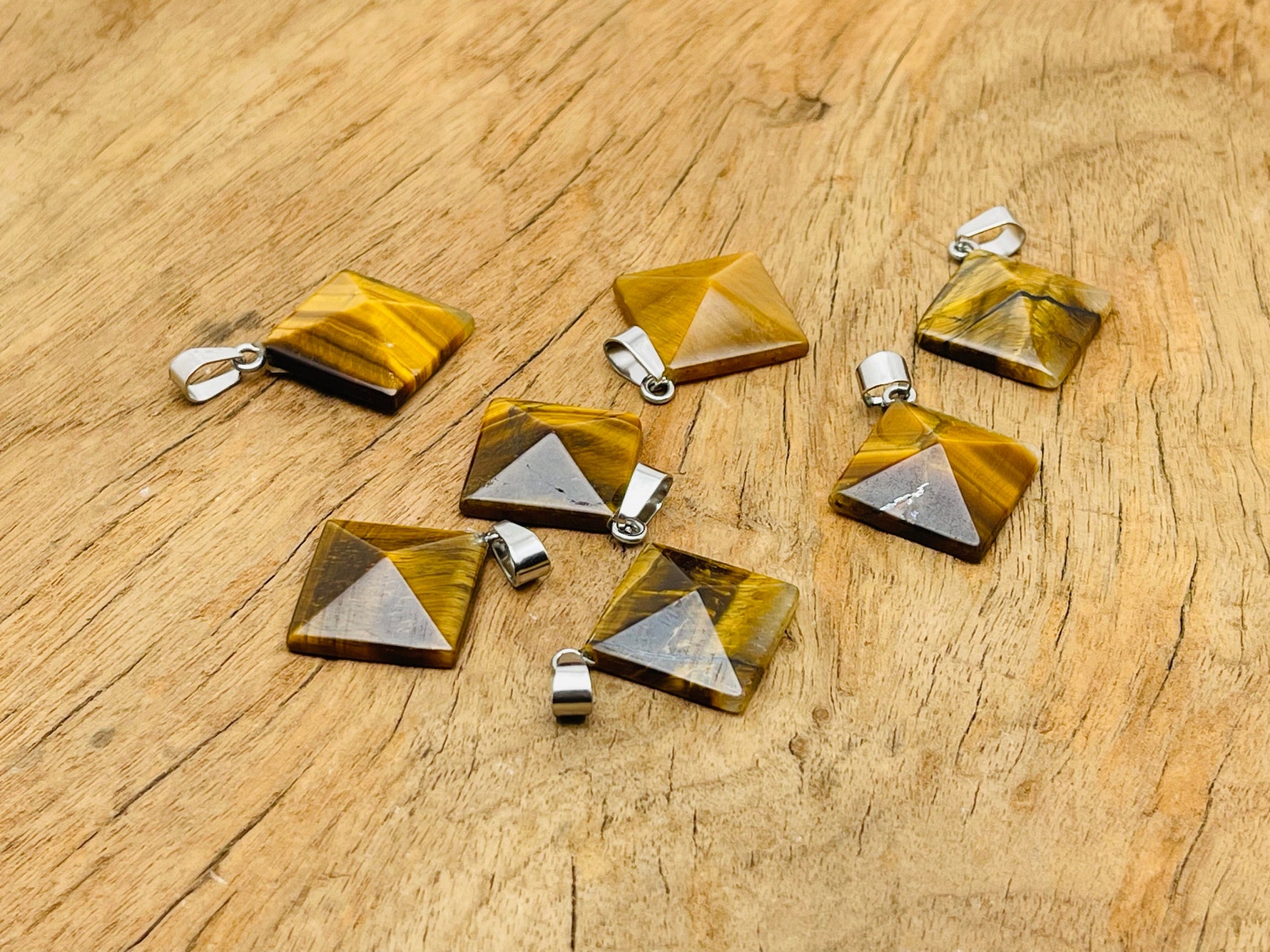 Tiger Eye pyramid gemstone pendant from GemstoneGO, showcasing a polished natural gemstone with a pyramid shape and rich golden-brown color.