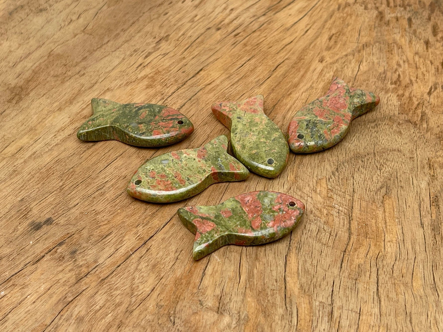 Unakite butterfly gemstone pendant hanging from a silver chain, showcasing vibrant orange and green colors in a crystal jewelry piece.