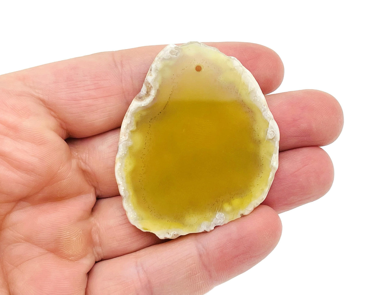 Yellow agate slice drilled pendant with natural geode features, showcasing vibrant yellow color and unique crystal interior.