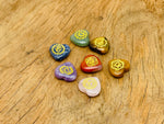 Heart-shaped chakra stones set with seven colorful crystals for meditation and healing, arranged in a decorative display.