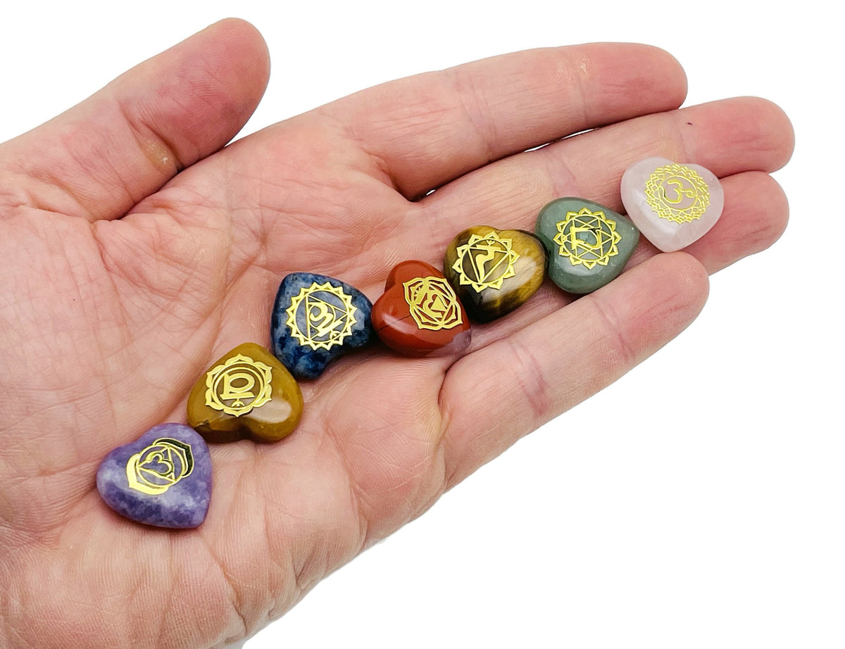 Set of seven heart-shaped chakra stones from GemstoneGO, used for meditation and crystal healing, displayed on a white background.