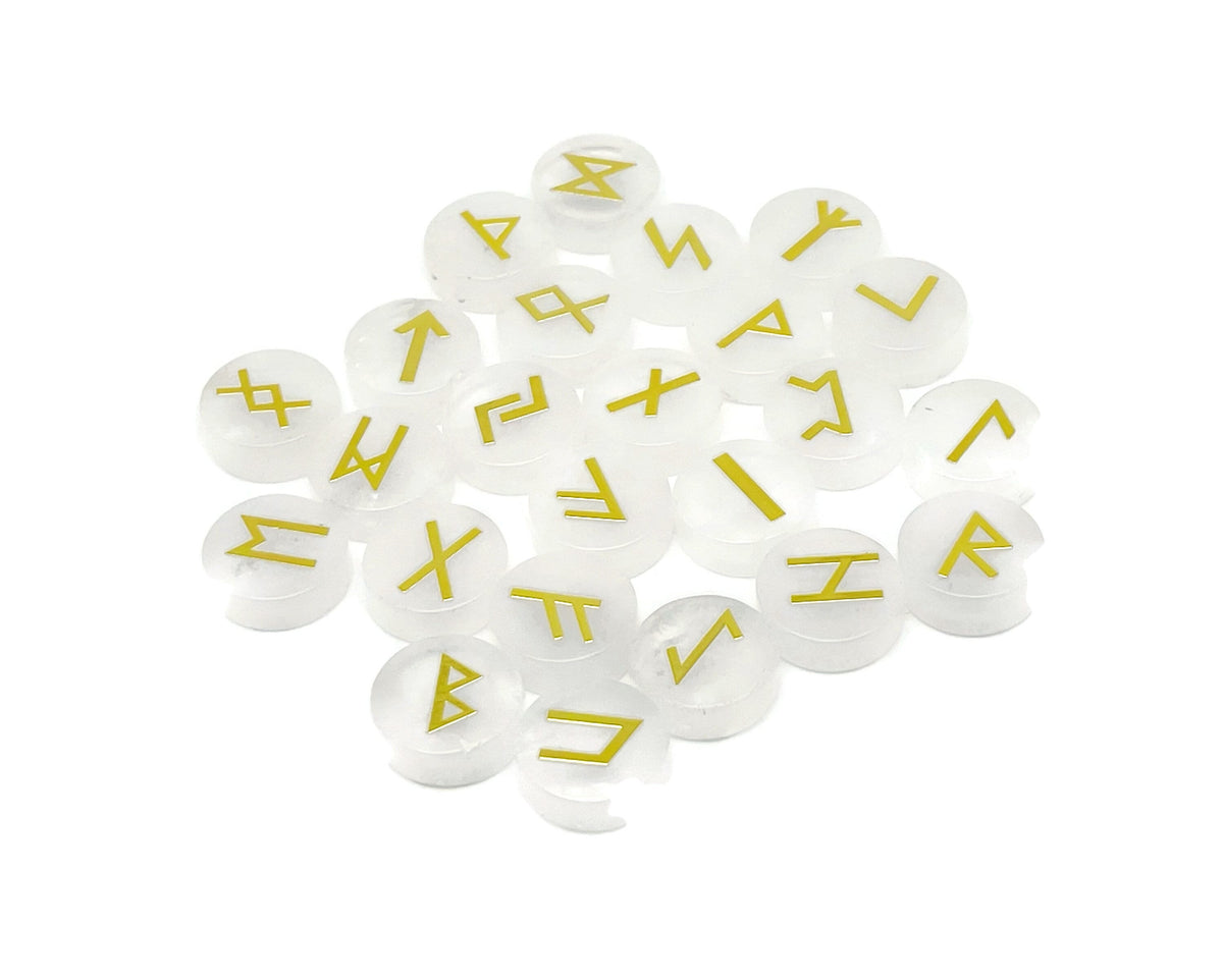 Set of 25 clear quartz crystal rune stones engraved with Elder Futhark alphabet from GemstoneGO, arranged in a display.