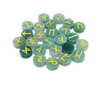 A set of 25 carved aventurine crystal rune stones with Elder Futhark alphabet engravings, arranged in a natural display.