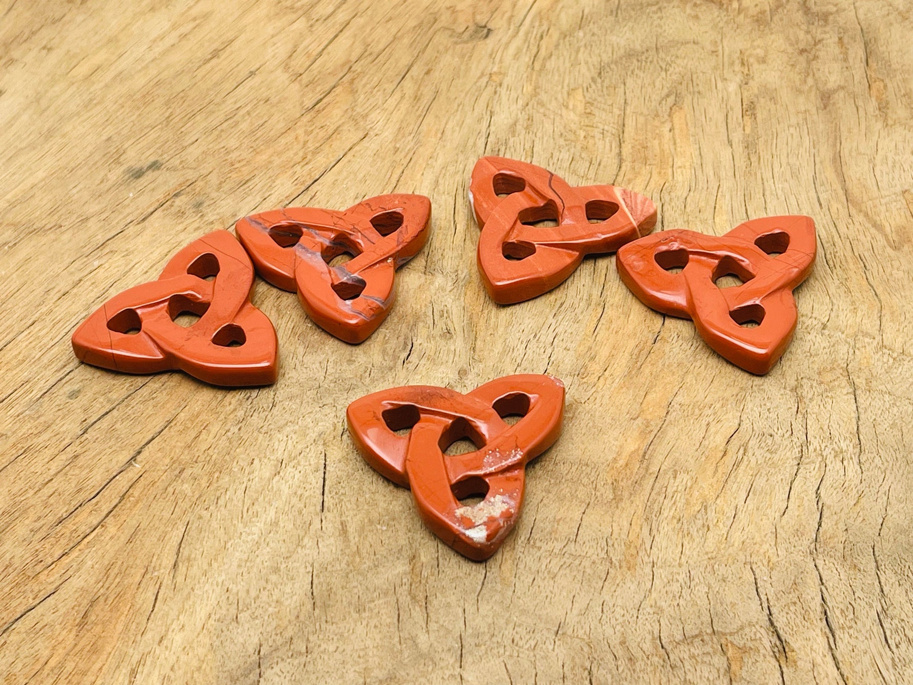 Red Jasper Celtic knot carved gemstone pendant with Trinity Crystal design by GemstoneGO, showcasing intricate knotwork and vibrant red color.