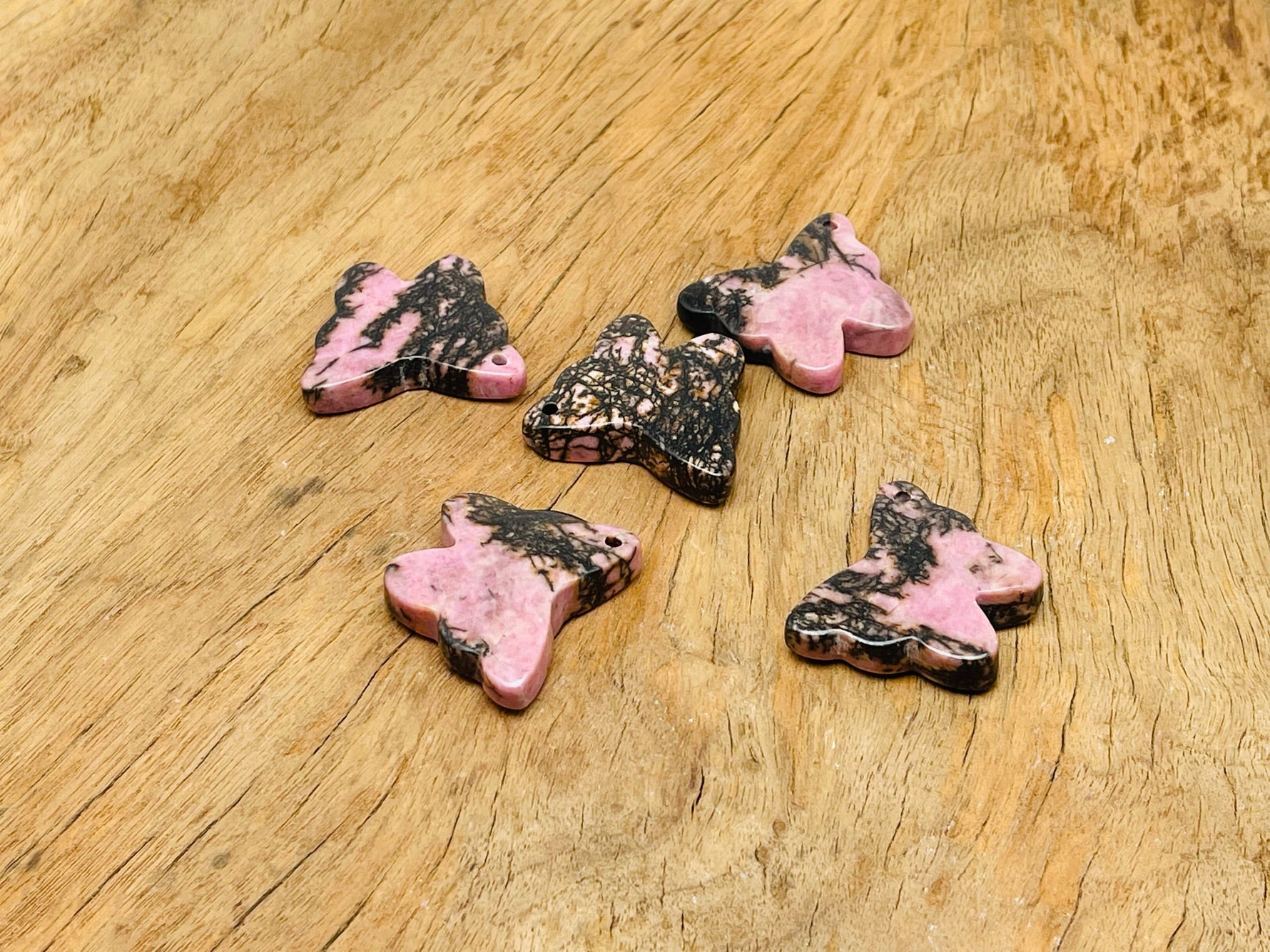 Rhodonite butterfly gemstone pendant with hole crystal jewelry featuring a vibrant pink and black patterned stone.