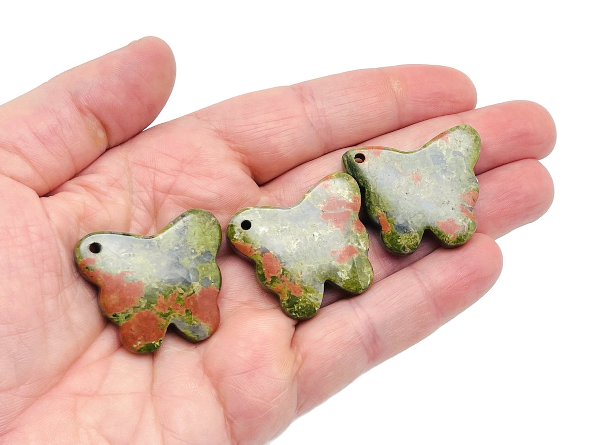 Unakite butterfly gemstone pendant with hole for crystal jewelry, featuring vibrant green and pink hues on a silver chain.