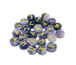 Set of 25 amethyst crystal rune stones engraved with Elder Futhark alphabet, arranged in a display.