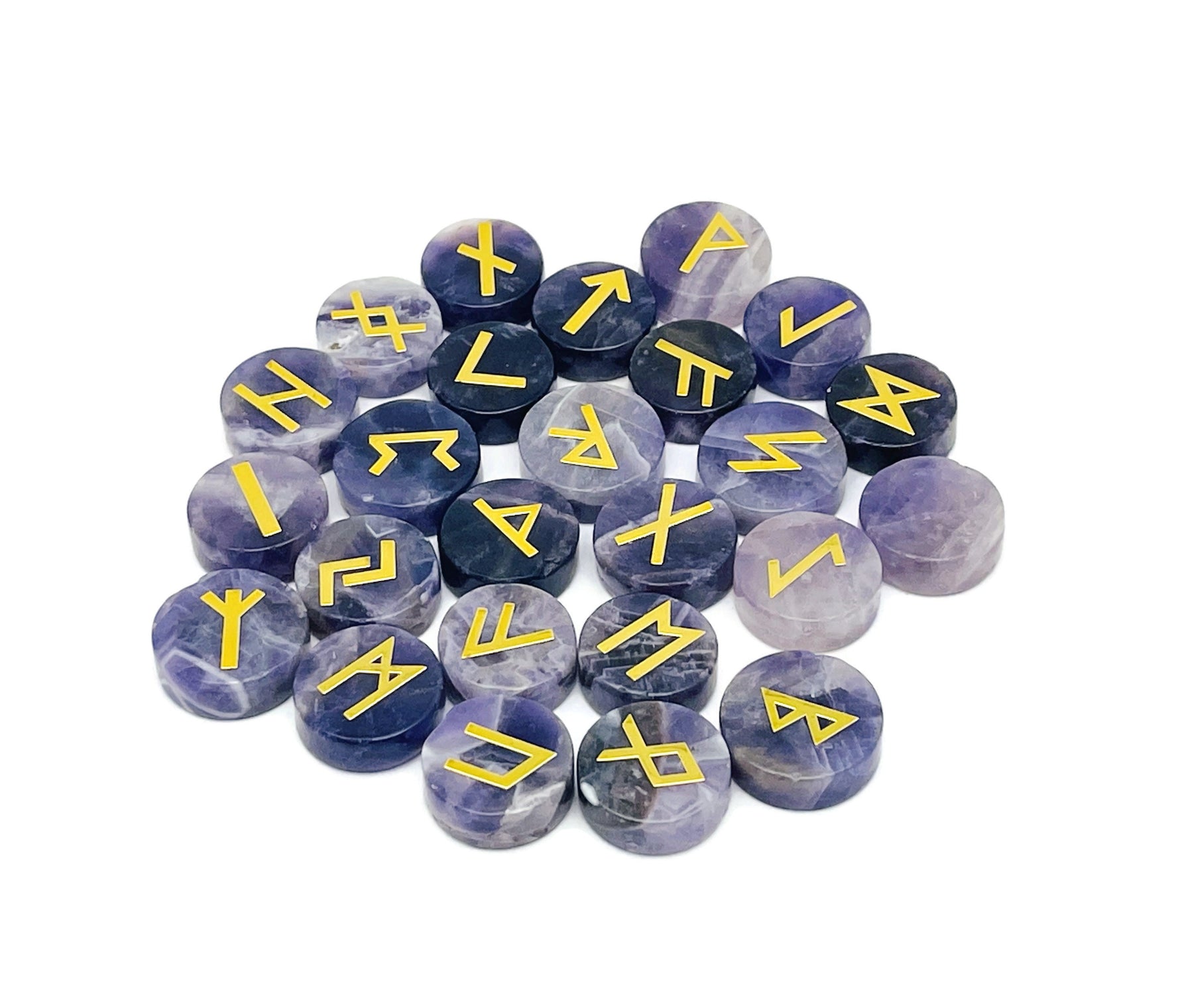 Set of 25 amethyst crystal rune stones engraved with Elder Futhark alphabet, arranged in a display.