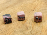 Handmade Rhodonite gemstone skull carving by GemstoneGO, detailed crystal sculpture suitable as a gift or decorative piece