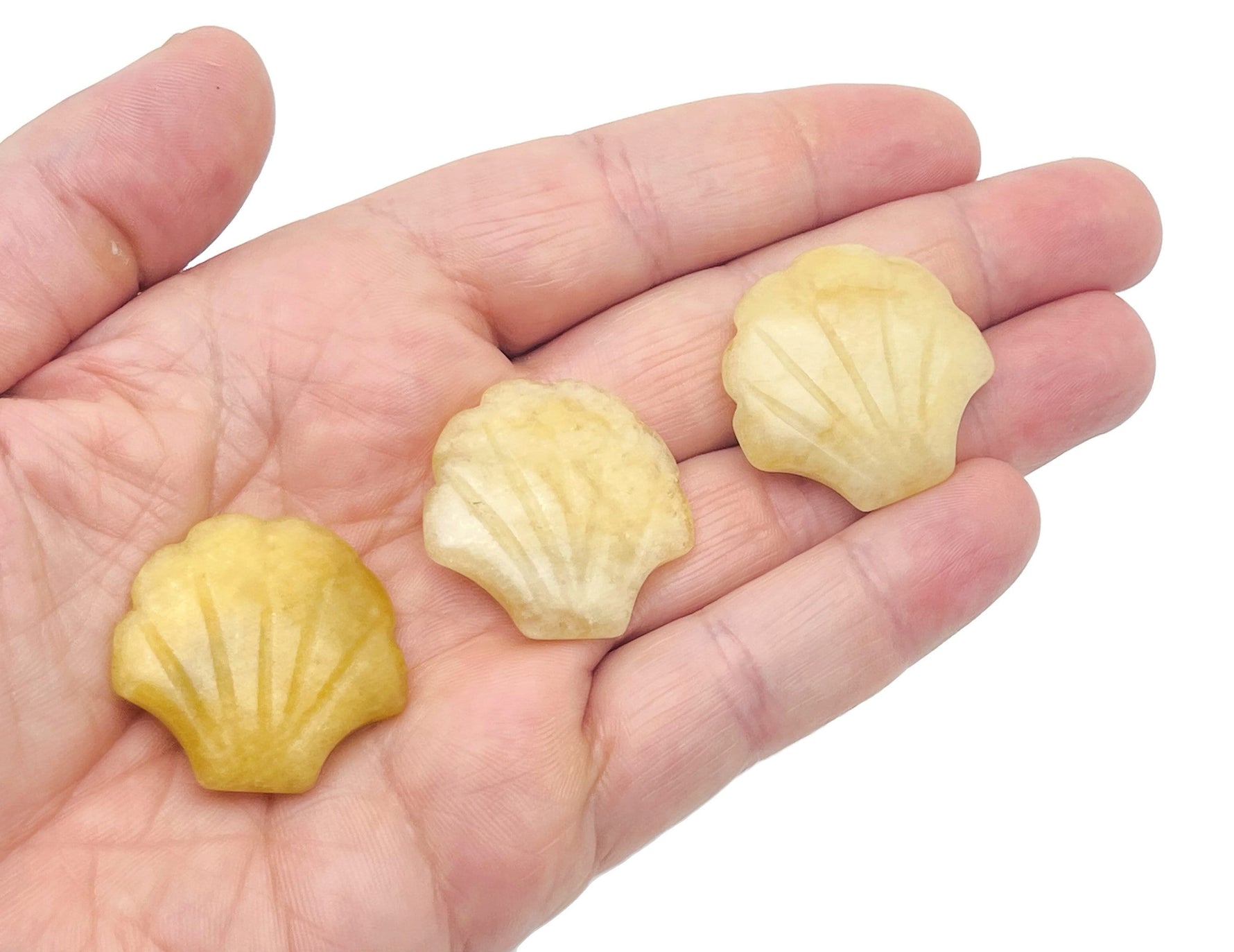 Yellow jade sea shell carving gemstone, 30mm, from GemstoneGO, showing detailed yellow jade and shell design on a white background.