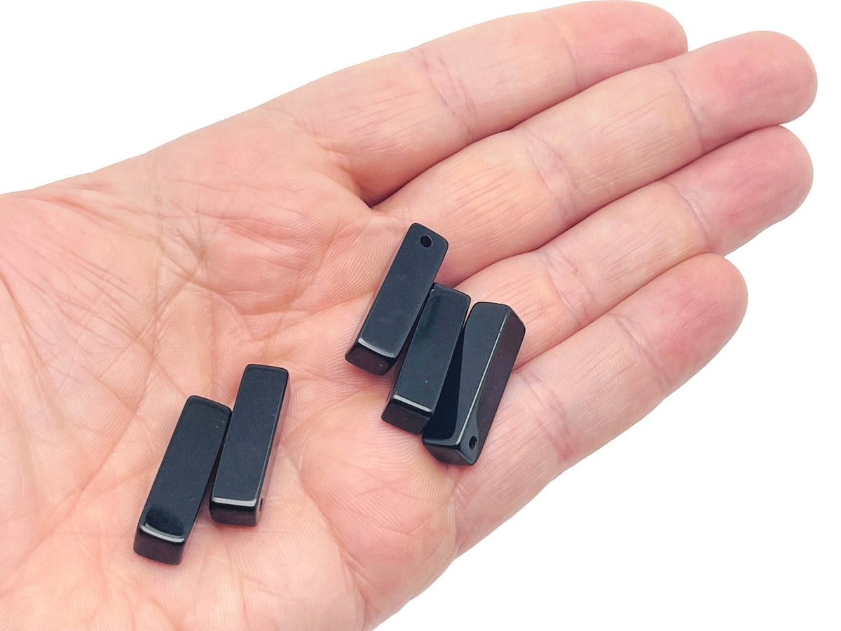 Drilled obsidian crystal pendant from GemstoneGO, showcasing a smooth, polished black stone ready for jewelry making.