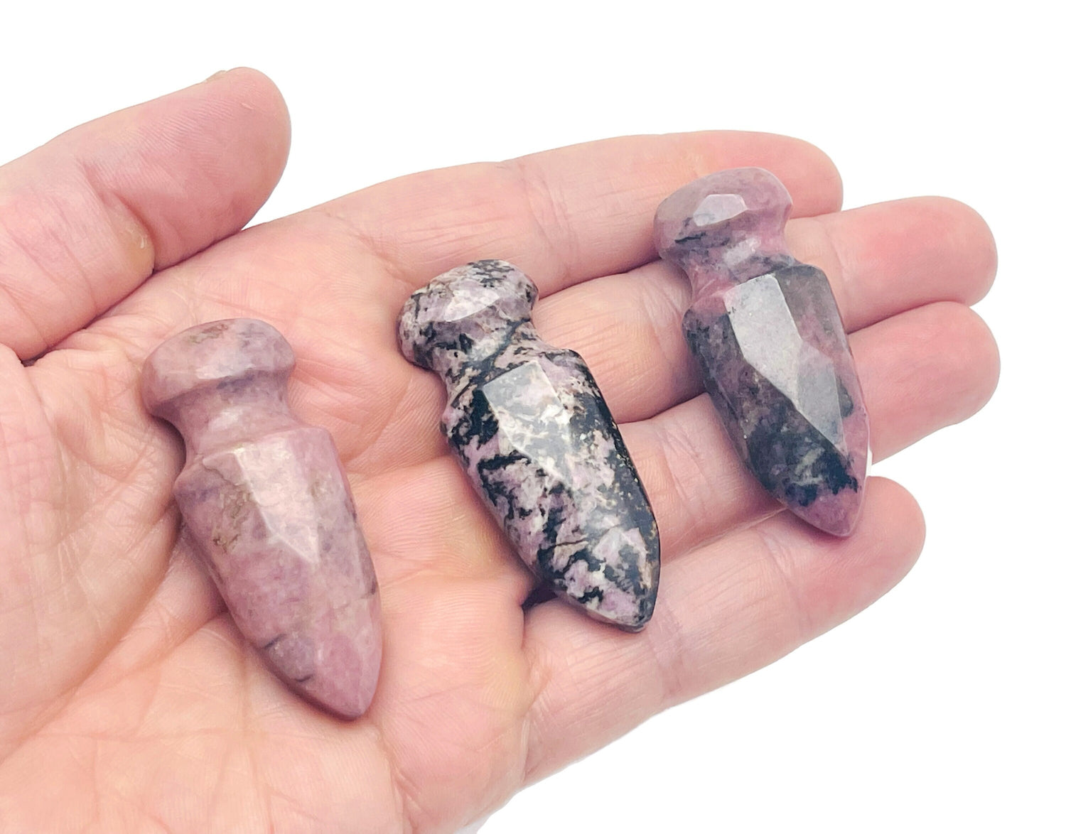 Carved rhodonite sword dagger gemstone pendant, 50mm, with intricate details and vibrant pink-red color, from GemstoneGO.