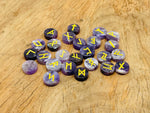 Set of 25 engraved amethyst crystal rune stones with Elder Futhark alphabet for divination and crystal healing.