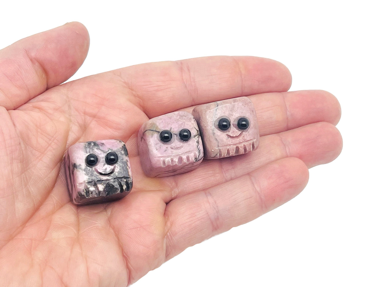 Handmade Rhodonite gemstone carving skull with detailed features, showcasing vibrant pink and black patterns, ideal as a crystal gift.