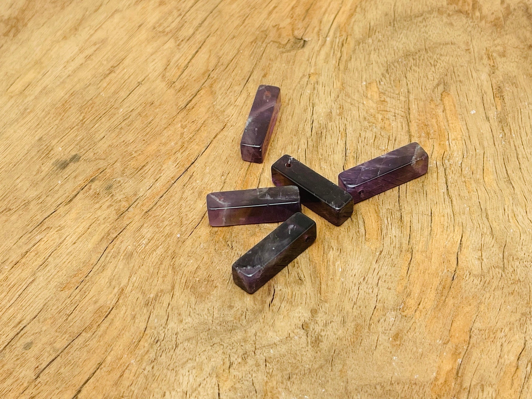 Amethyst crystal pendant from GemstoneGO, drilled for jewelry making, showcasing a purple gemstone with natural facets and polished surface.