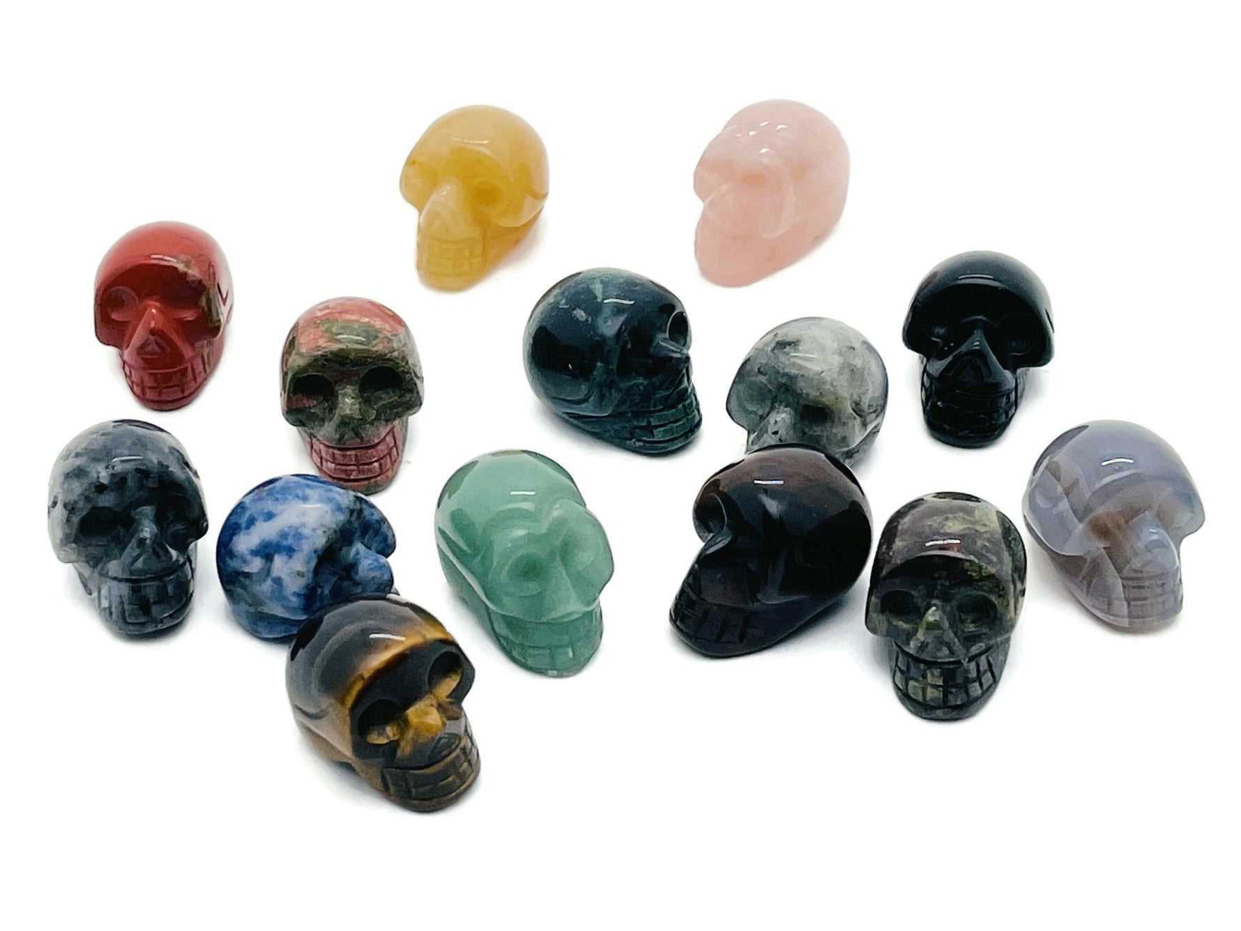 Seven assorted gemstones in a crystal mystery box gift featuring a carved skull design by GemstoneGO.