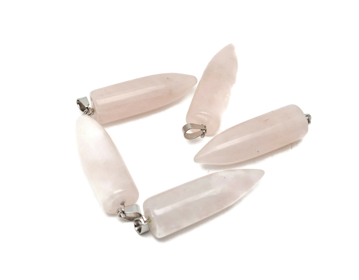 Polished rose quartz bullet gemstone pendant with carved details, showcasing a smooth, rounded shape and natural pink hue.