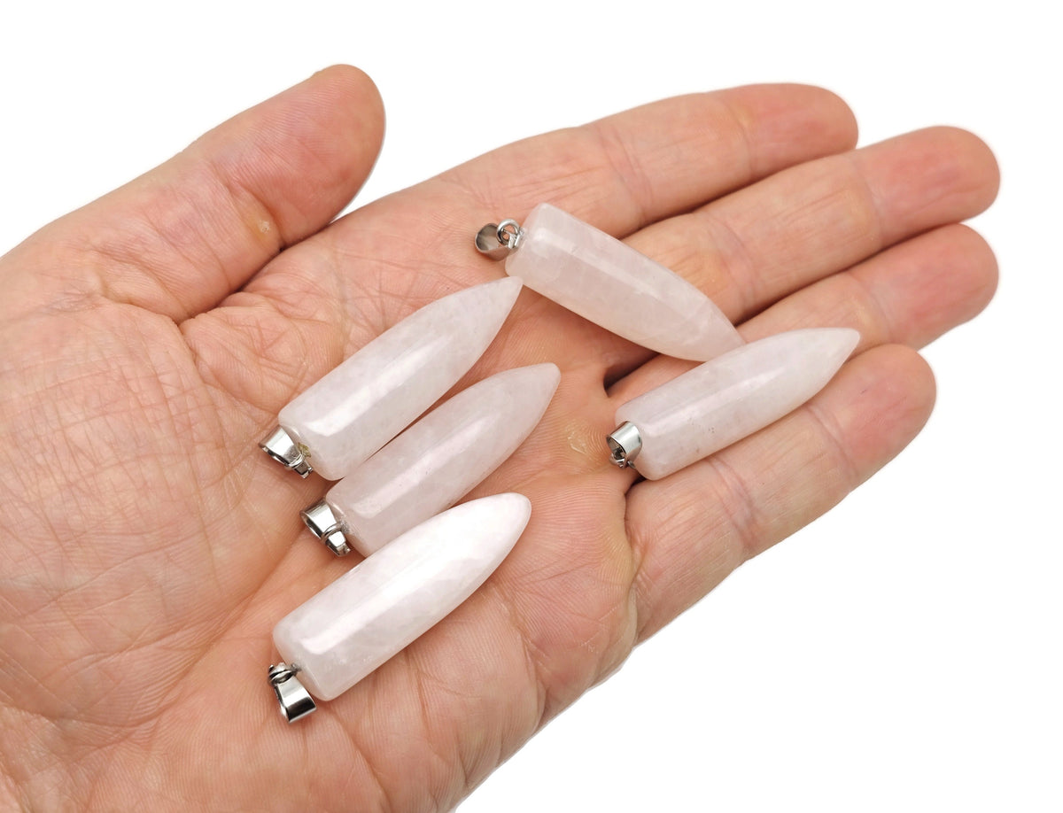 Polished rose quartz bullet gemstone pendant with carved details, hanging on a silver chain, from GemstoneGO.