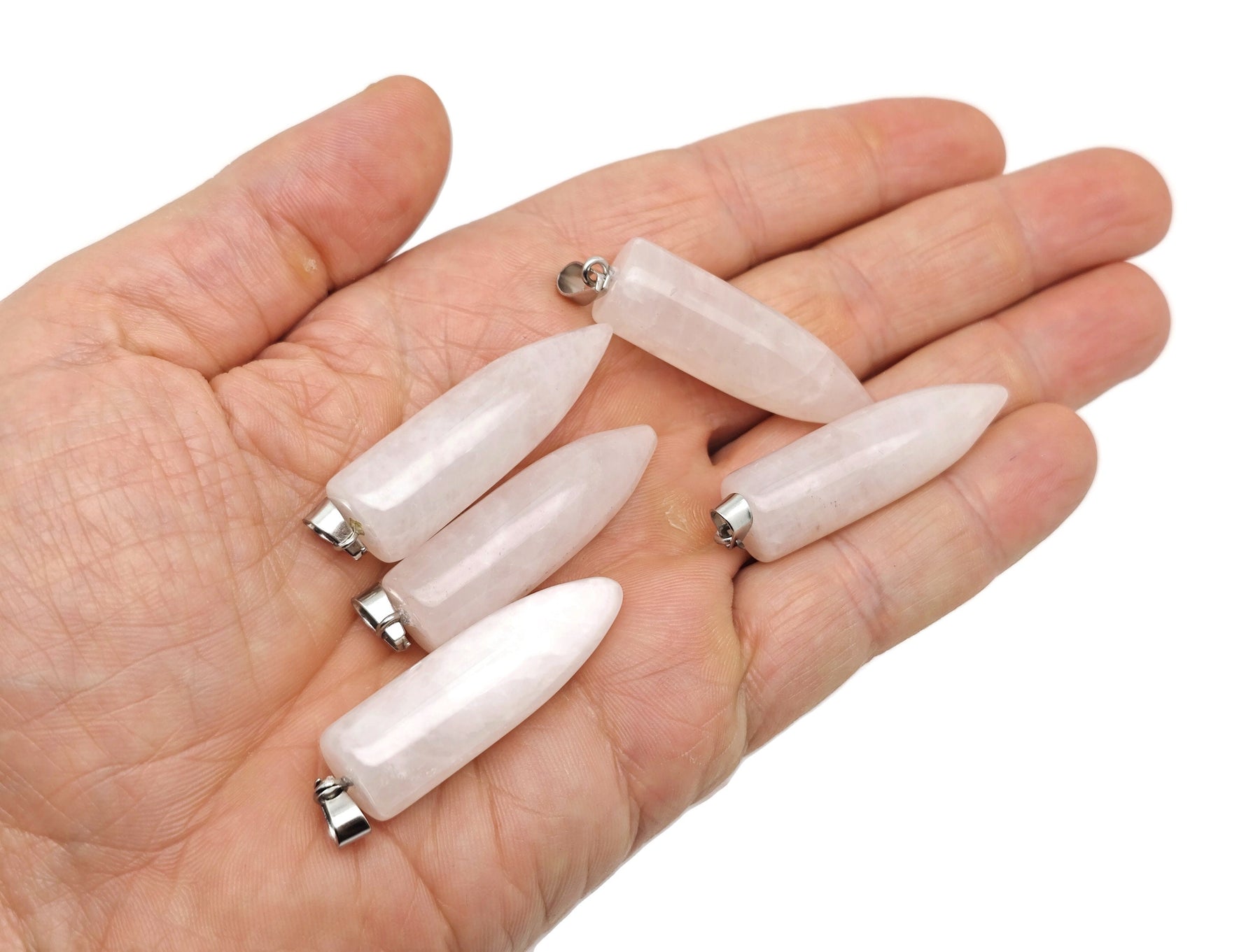 Polished rose quartz bullet gemstone pendant with carved details, hanging on a silver chain, from GemstoneGO.