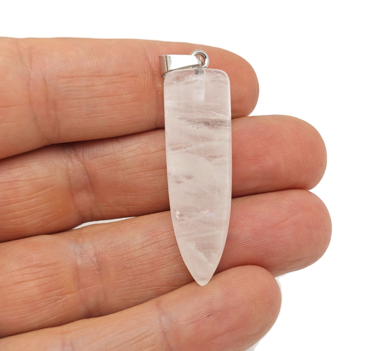 Polished clear quartz bullet gemstone pendant with carved details, showcasing a smooth, transparent stone on a jewelry chain.