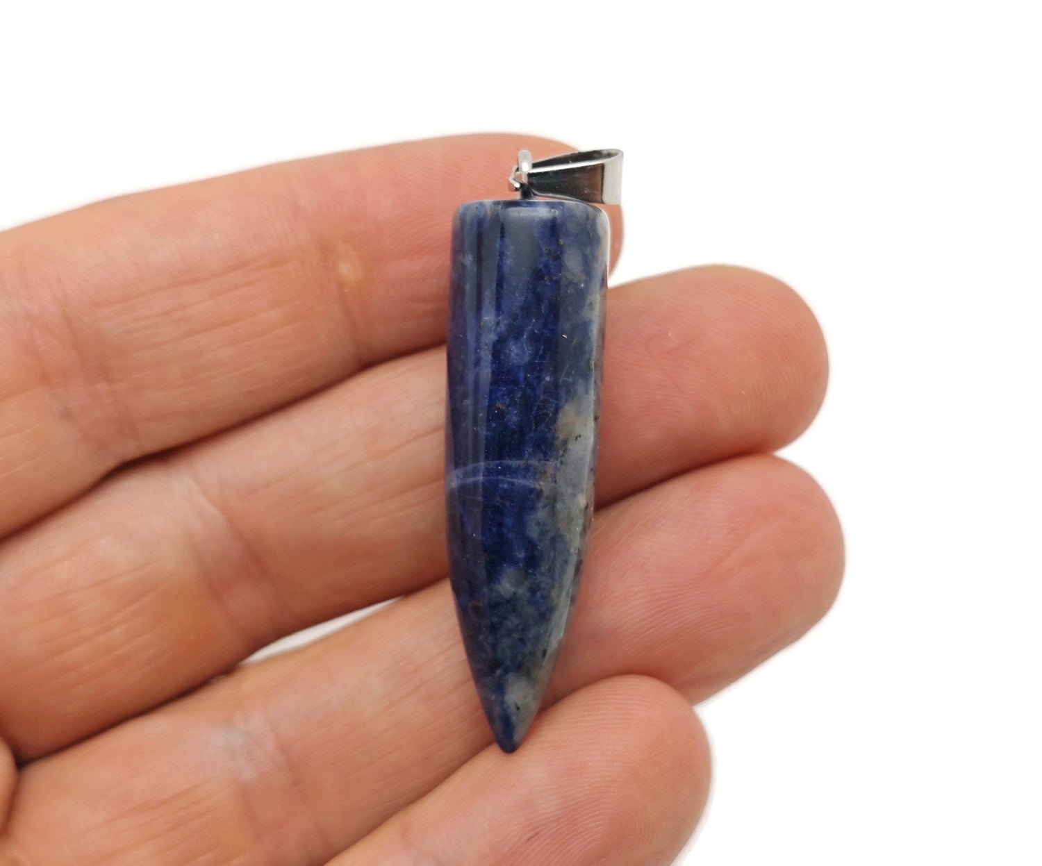 Polished sodalite bullet gemstone pendant with carved details, showcasing deep blue and white natural stone patterns.