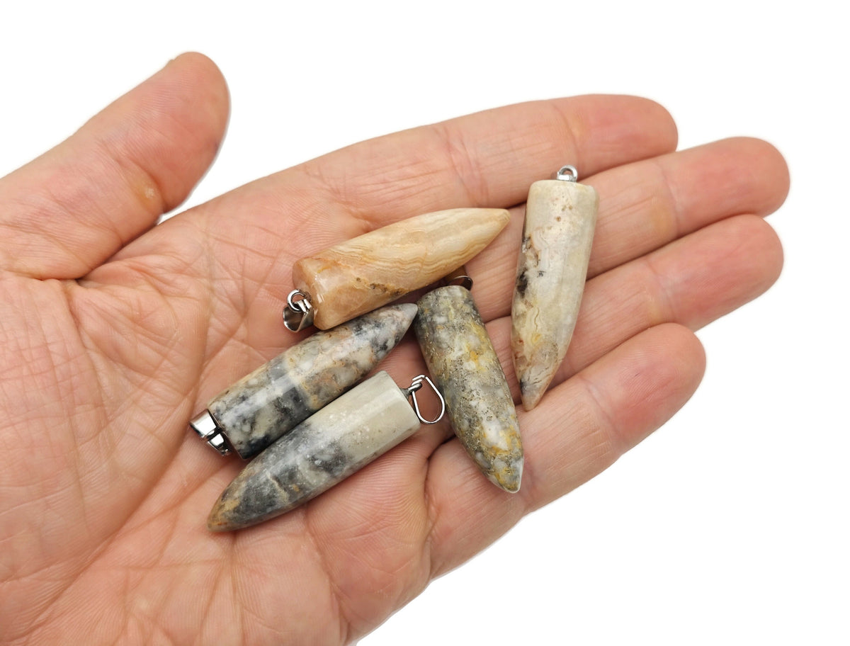 Polished Crazy Lace Agate bullet gemstone pendant with carved details, featuring vibrant patterns and a smooth, polished finish.