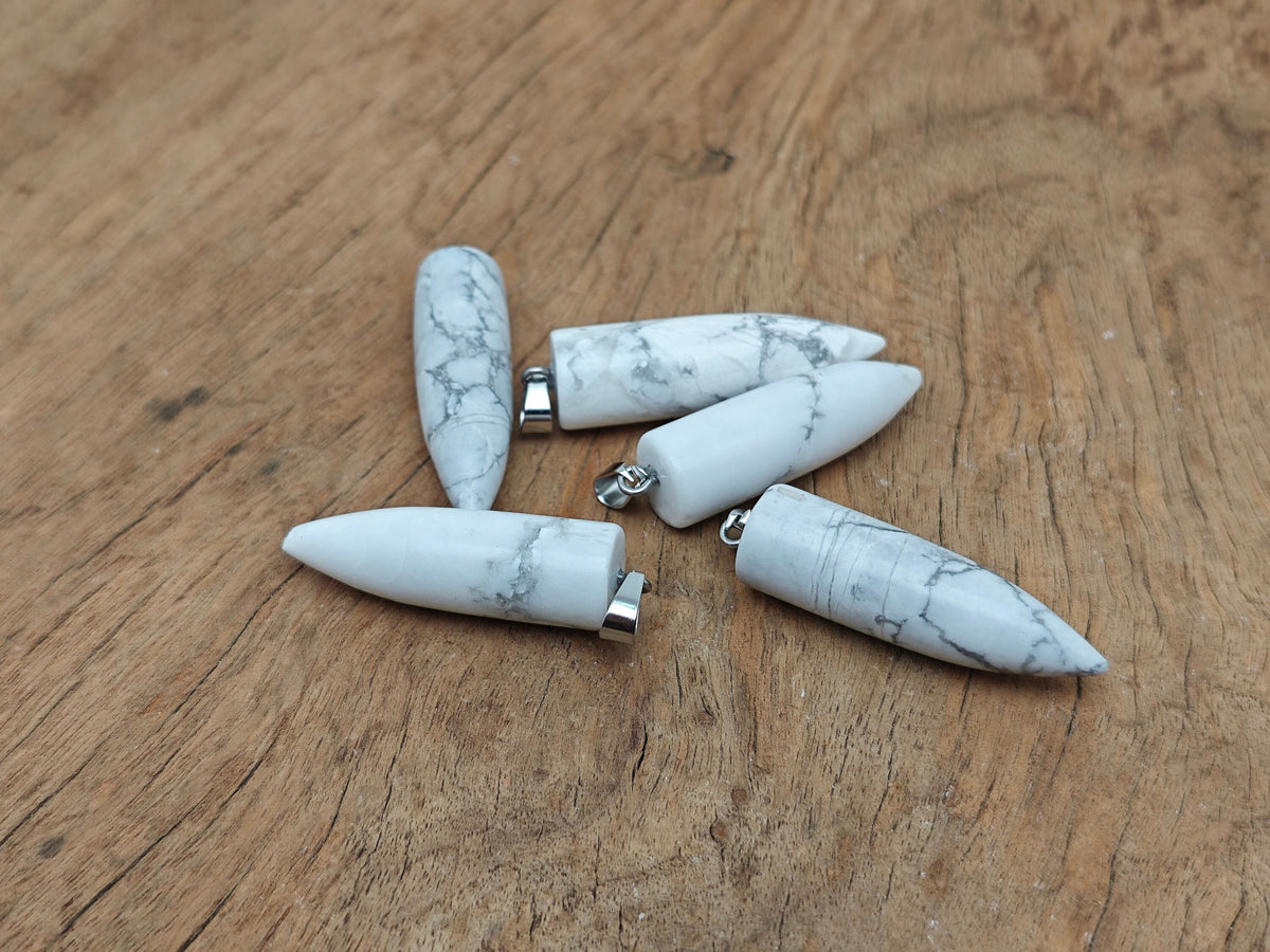 Polished Howlite bullet gemstone pendant with carved details, featuring a smooth, polished finish and natural white and gray colors.